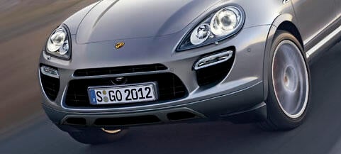 Porsche Cayenne kör nerför vägen. (AI text)