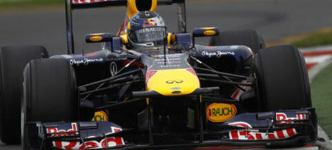 Rött Bull-racingbil kör längs banan. (AI text)