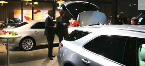 En grupp personer tittar på bilar på en bilmesse. (AI text)