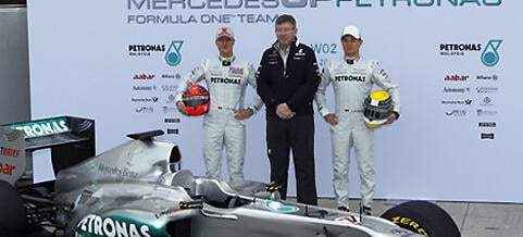 Mercedes F1-stall poserar med sin nya bil. (AI text)