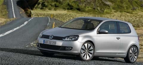 En silverfärgad Volkswagen Golf kör nedför en bergsväg. (AI text)