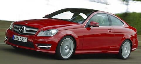 Mercedes C-kupé kör på en väg. (AI text)