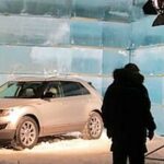 En bil är parkerad i en snöig parkeringsplats. (AI text)