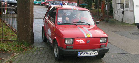 En röd bil parkerad på en gata (AI text)