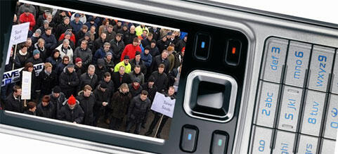 En mobiltelefon med en bild av en folksamling. (AI text)