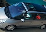En silverfärgad bil kör längs en väg. (AI text)