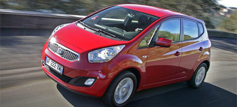 En röd bil kör nerför en väg. (AI text)