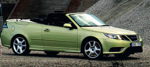 En grön Saab C1 roadster parkerad på grus. (AI text)