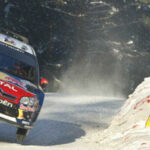 En rallybil hoppar över en snöig backe. (AI text)