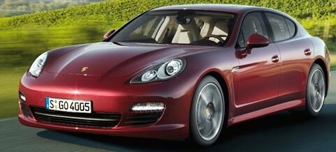 En röd Porsche Panamera kör nerför en väg. (AI text)