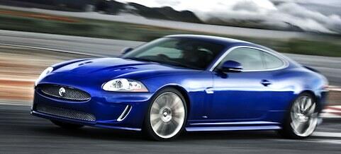 En blå Jaguar XKR kör på en racerbana. (AI text)