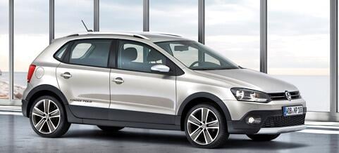 En silverfärgad Volkswagen Cross parkerad framför ett stort fönster. (AI text)