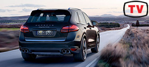 En svart Porsche Cayenne kör nerför en landsväg. (AI text)