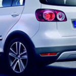 En vit Volkswagen Polo parkerad på en gata. (AI text)