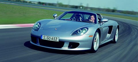 En silverfärgad Porsche Boxster sportbil kör på en racebana. (AI text)