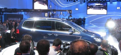 En grupp personer samlas runt en bil. (AI text)