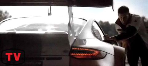 En man står bredvid en Porsche 911 GTS. (AI text)