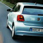 En Volkswagen up! kör nedför en landsväg. (AI text)