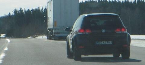 En bil kör nedför en motorväg. (AI text)