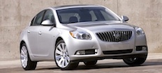 En silverfärgad Buick Regal parkerad framför en betongvägg. (AI text)