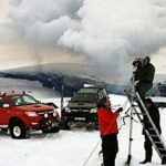 En grupp personer står på ett snöklätt bergstopp. (AI text)