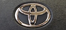 En Toyota-logga på dashboardskivan i en bil (AI text)
