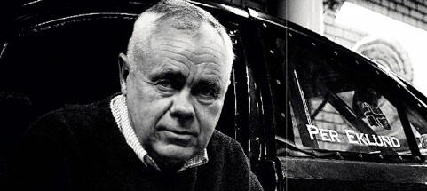 En man i en svart bil med en skylt på den. (AI text)