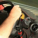 En man kör en bil på en racerbana. (AI text)