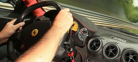 En man kör en bil på en racerbana. (AI text)