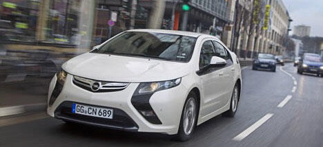 En vit Opel Viva kör nedför en stadsgata. (AI text)