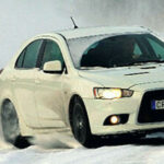 En vit bil kör genom snön. (AI text)