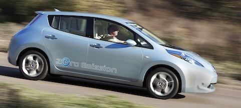 En Nissan Leaf elbil kör nerför en landsväg. (AI text)