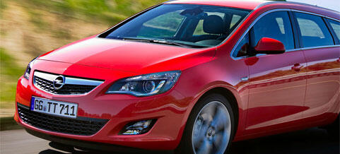 En röd Opel Astra kör längs en landsväg. (AI text)