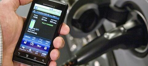 En person använder en smartphone för att ladda sin bil. (AI text)