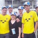 En grupp personer poserar för ett foto vid en racerbana. (AI text)