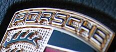 Porsche-logotyp på dashboardskivan i en bil (AI text)