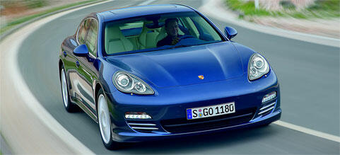 En blå Porsche Panamera kör längs en väg. (AI text)