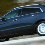 En Cadillac SRX kör nedför en väg. (AI text)