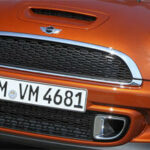 En Mini Cooper S kör ner vägen. (AI text)