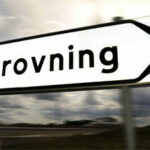 En vägmärke med ordet Bilprovning mitt på vägen. (AI text)