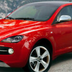 En röd Alfa Romeo SUV parkerad framför en bergstopp. (AI text)