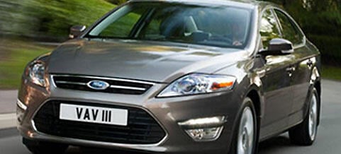 En silverfärgad Ford Mondeo kör nedför en väg. (AI text)