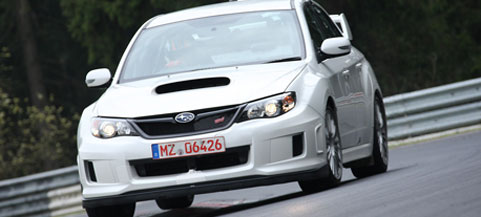 En vit Subaru WRX STI kör på en racerbana. (AI text)