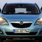 En blå Opel Zafira parkerad på stranden. (AI text)