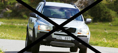 En bil kör nedför en väg med en skylt som säger "Nej till bilar". (AI text)