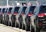 En rad svarta jeepar parkerade framför ett byggnad. (AI text)