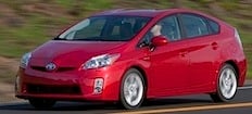 En röd Toyota Prius kör nedför en väg. (AI text)