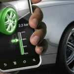 En man håller på med en smartphone medan han tittar på en bil. (AI text)