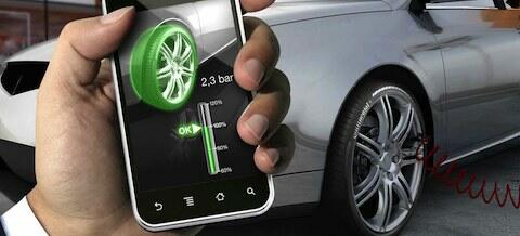 En man håller på med en smartphone medan han tittar på en bil. (AI text)