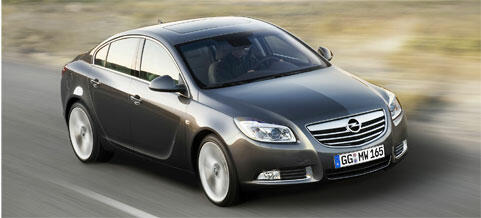 En grå Opel Insignia kör längs en väg. (AI text)